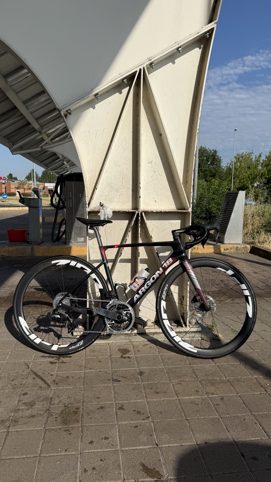 La bici da corsa Argon 18 con ruote Zipp appoggiata durante una sosta