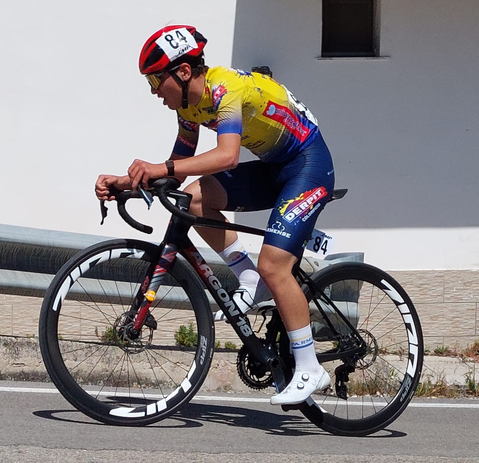 Cristian di profilo a ritmo in salita sulla sua Argon 18 con ruote Zipp