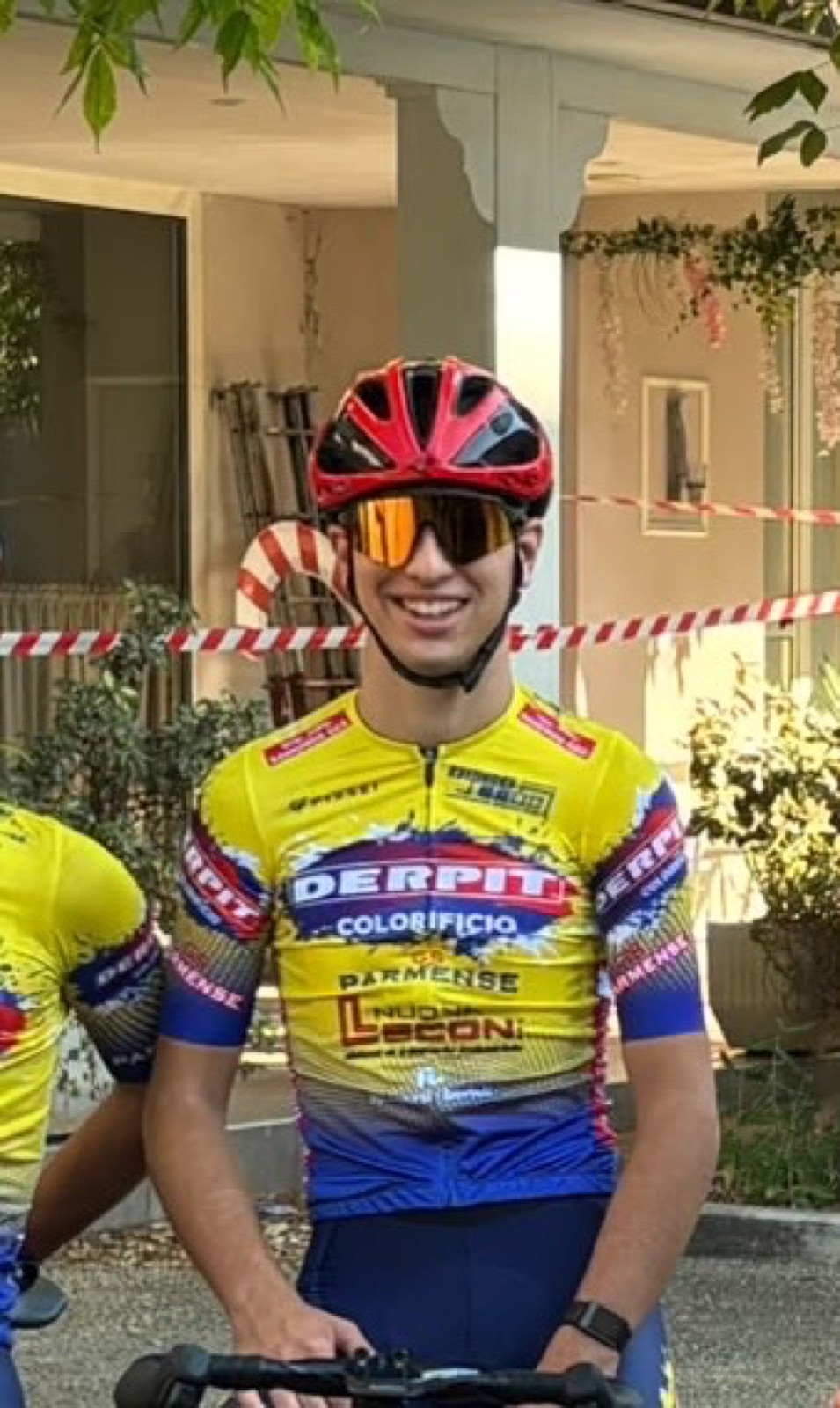 Cristian sorridente prima del via, casco rosso e occhiali arancioni