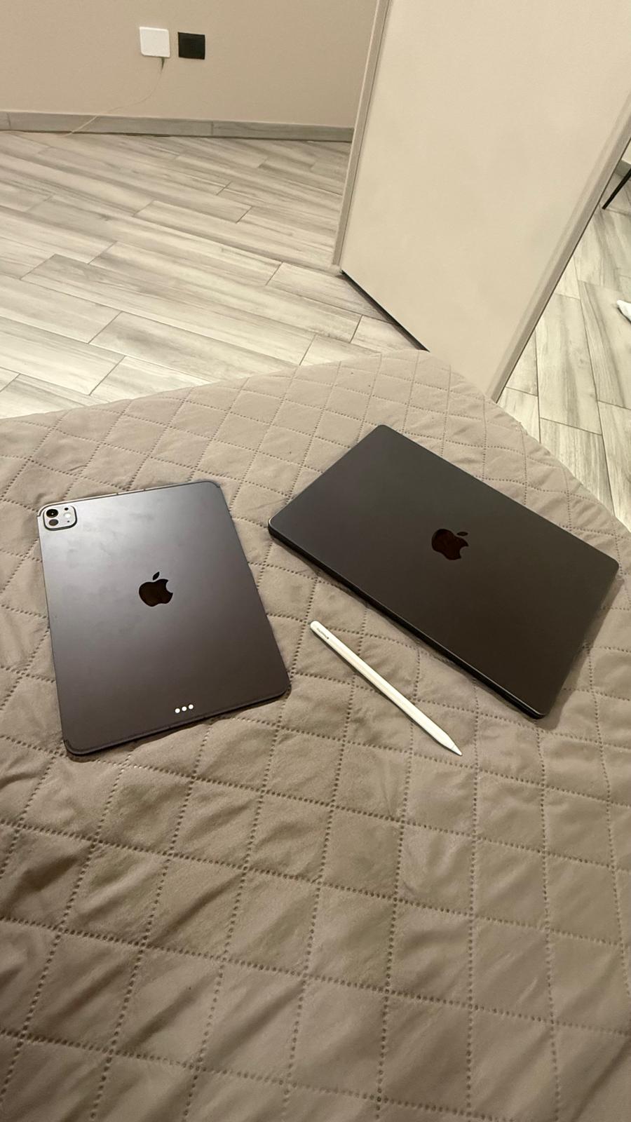 MacBook, iPad Pro e Apple Pencil appoggiati sul letto