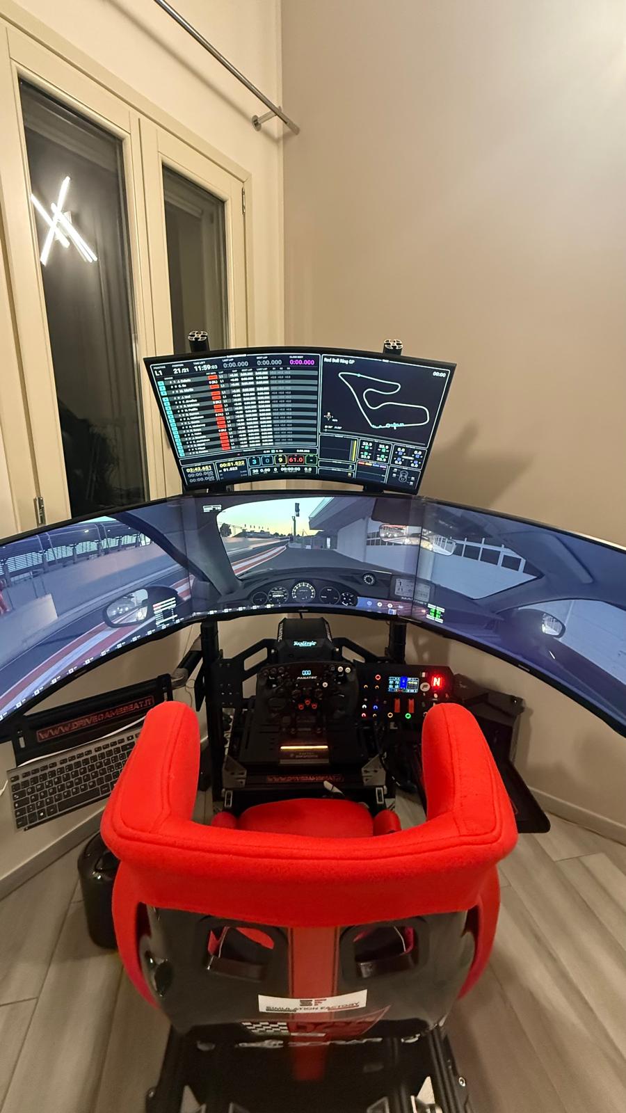 Postazione sim racing con cockpit, sedile rosso e tre monitor curvi con telemetria