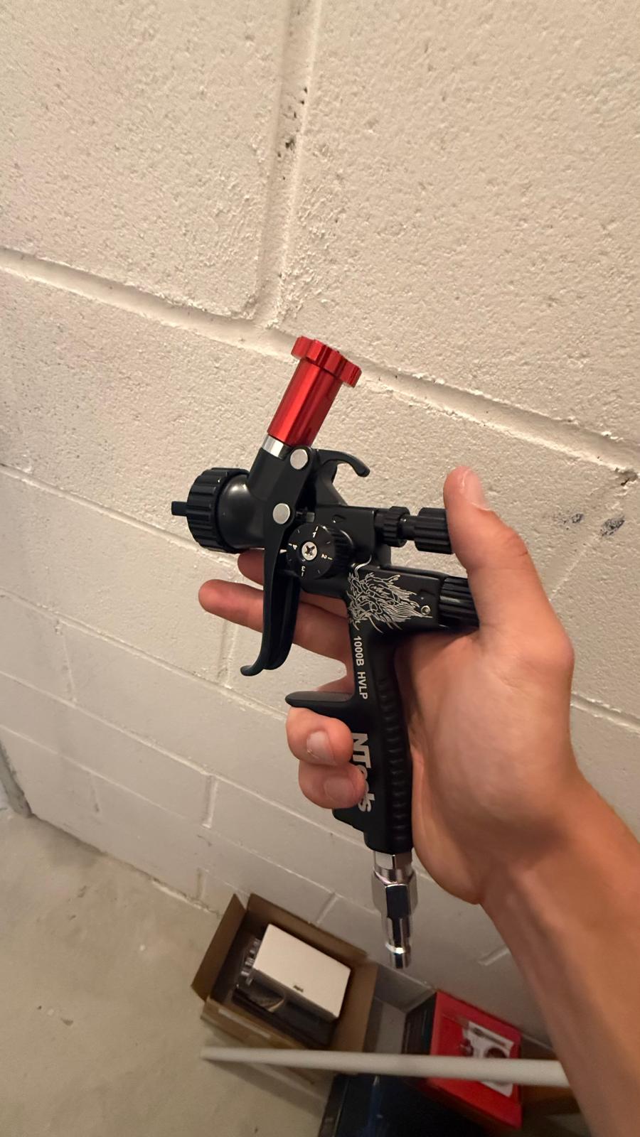 Mini pistola aerografo da ritocco impugnata in officina