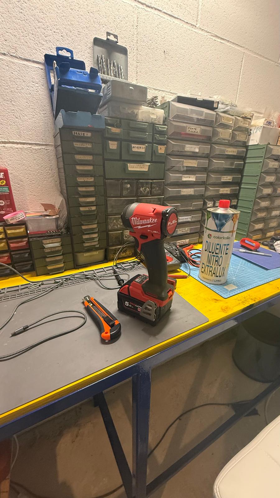 Banco officina con avvitatore Milwaukee, cassettiere di minuteria e diluente nitro