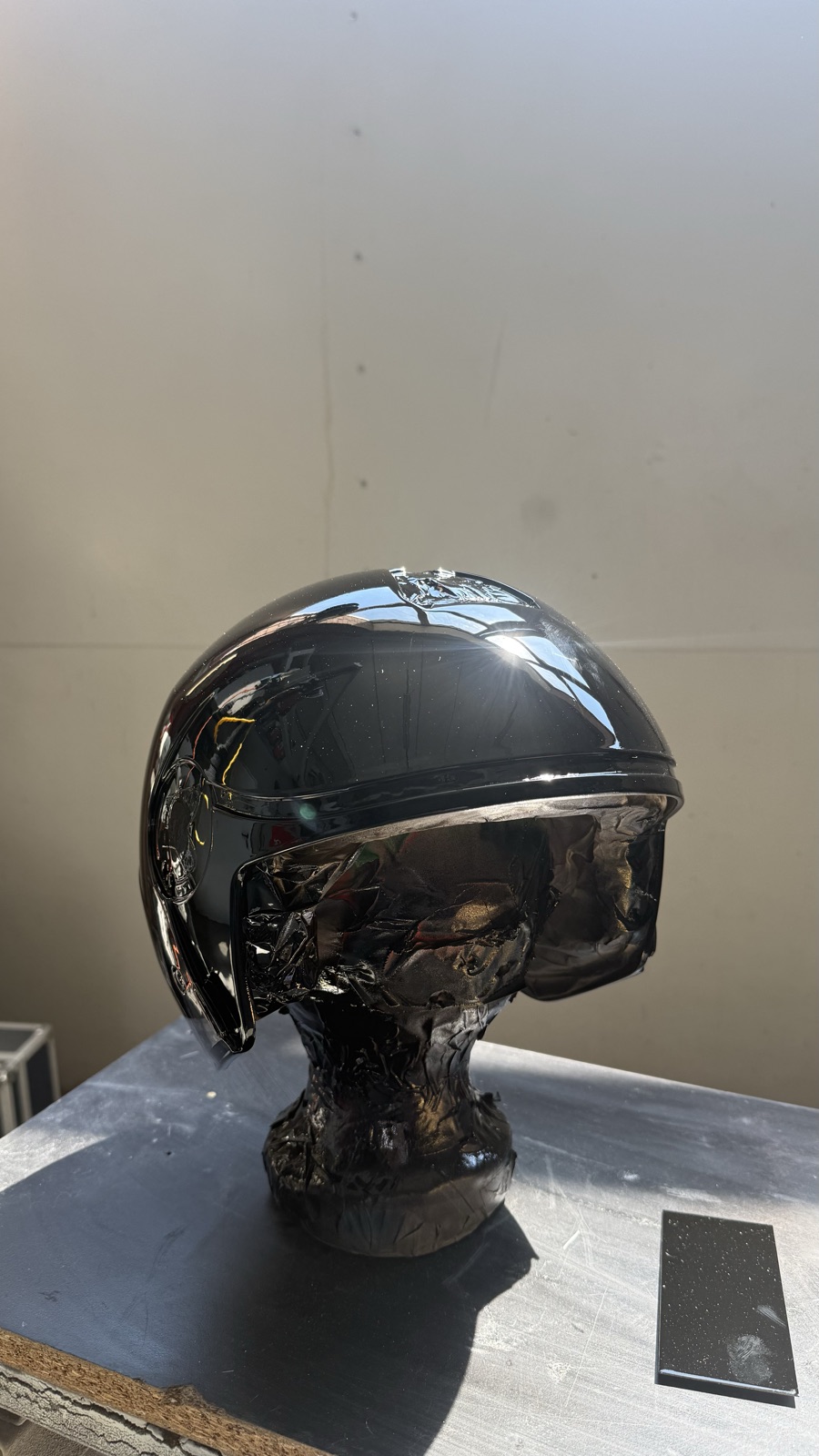 Casco jet verniciato nero lucido a specchio sul supporto