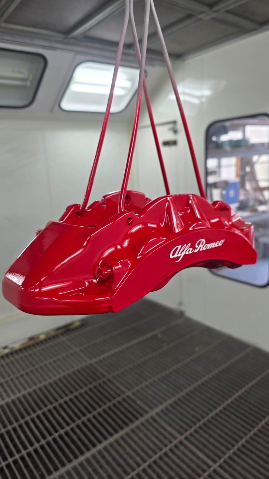 Pinza freno Alfa Romeo verniciata rosso lucido, appesa in cabina