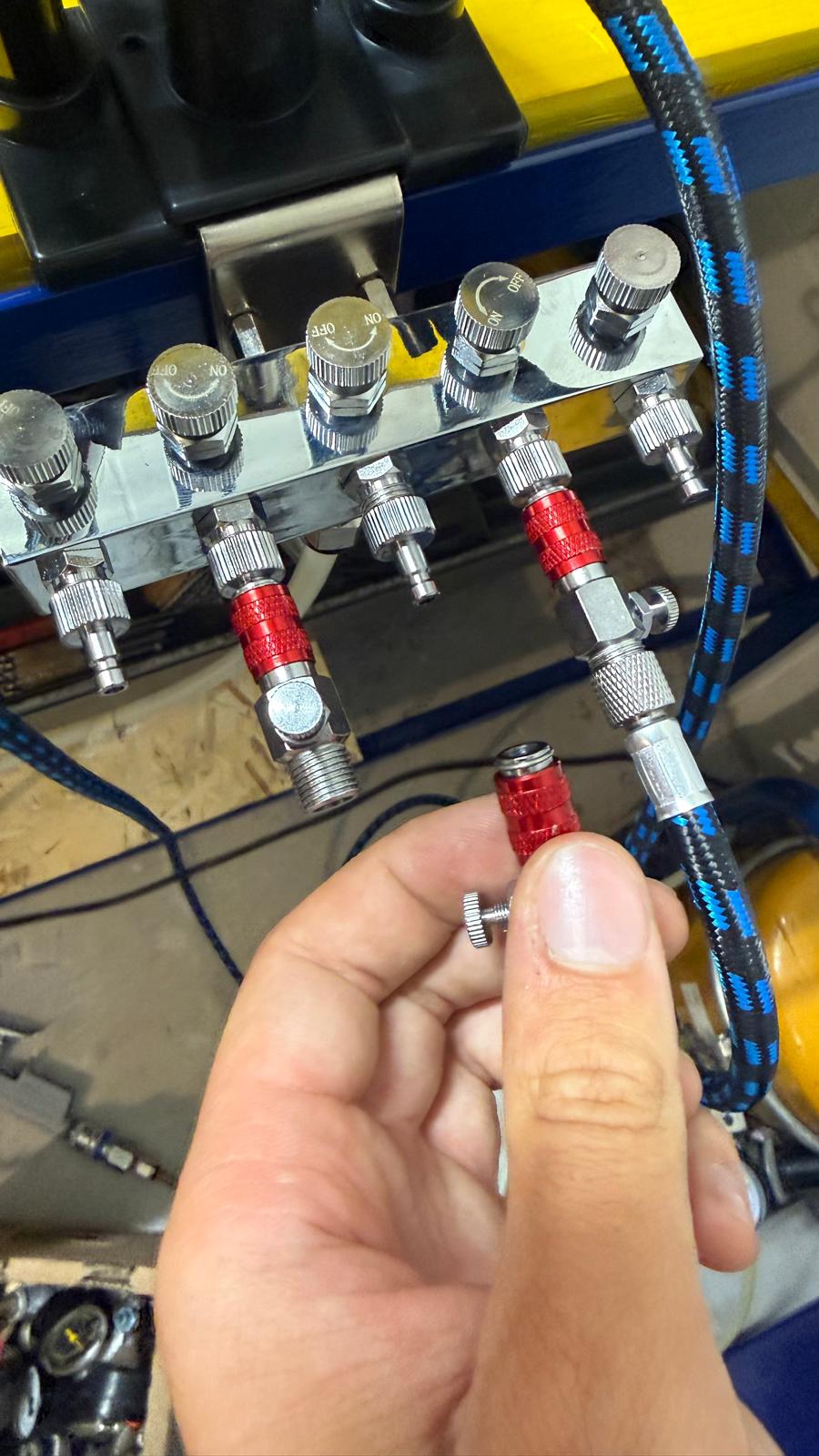 Raccordi rapidi per aria compressa montati sul collettore, uno in mano
